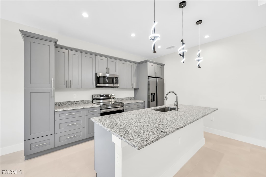 8771-8773 Buckingham Road Lehigh Acres, FL 33971 - Photo 2 of 34 a kitchen with kitchen island a sink stainless steel appliances and counter space
