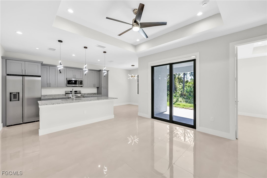 8771-8773 Buckingham Road Lehigh Acres, FL 33971 - Photo 21 of 34 a view of kitchen with stainless steel appliances granite countertop a stove a refrigerator a sink a island with a dining table and chairs