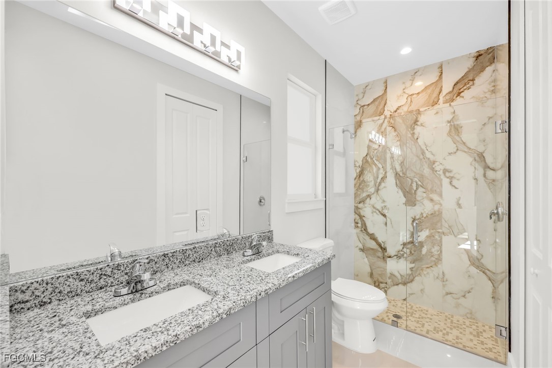 8771-8773 Buckingham Road Lehigh Acres, FL 33971 - Photo 28 of 34 a bathroom with a granite countertop sink toilet and shower