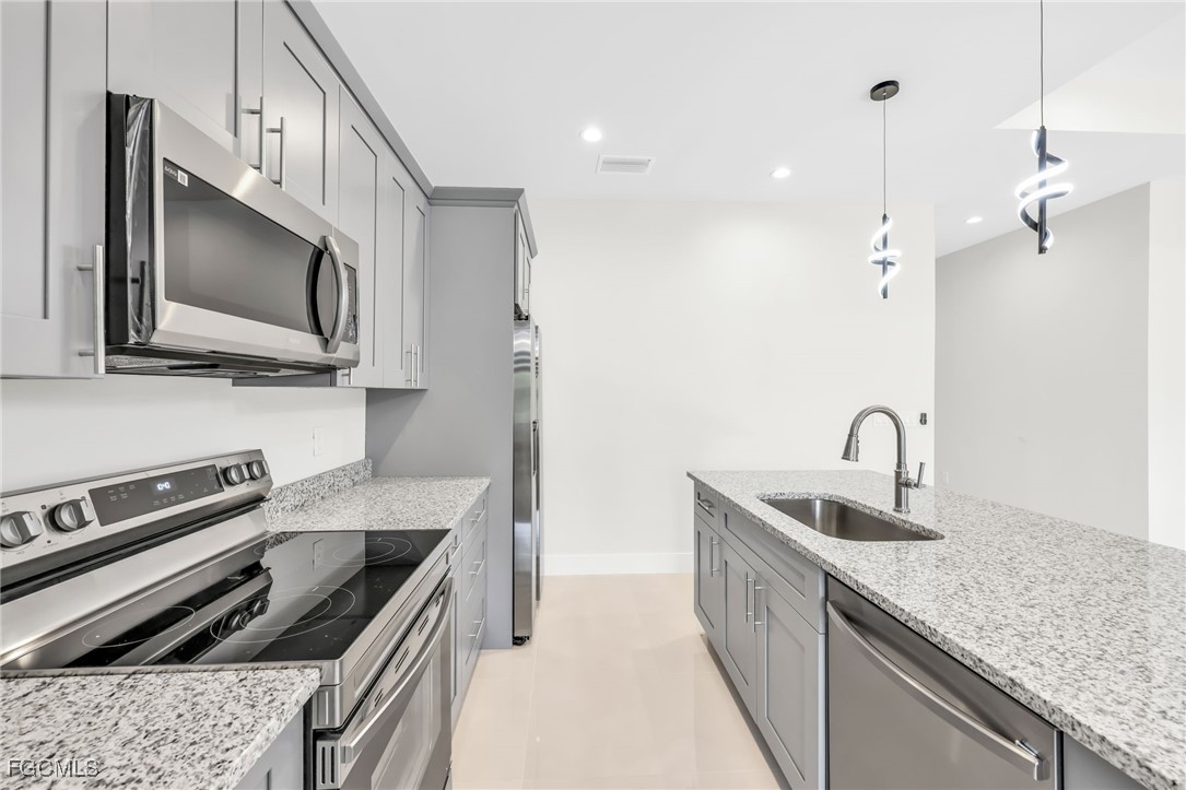 8771-8773 Buckingham Road Lehigh Acres, FL 33971 - Photo 6 of 34 a kitchen that has a sink and a stove