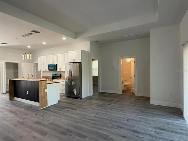 a view of kitchen with stainless steel appliances granite countertop a refrigerator and a sink