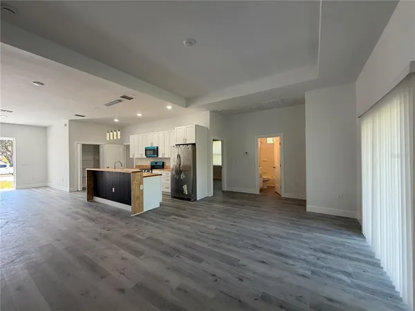 a view of a big room with wooden floor and windows