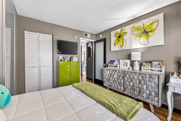 a bedroom with a large bed and a flat tv screen