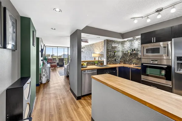 a kitchen with stainless steel appliances kitchen island granite countertop a refrigerator and a sink