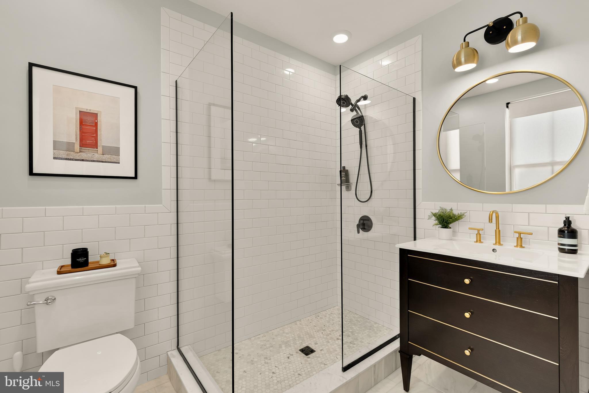 409 Columbia Road Northwest Washington, DC 20001 - Photo 27 of 41 a bathroom with a toilet a sink and mirror