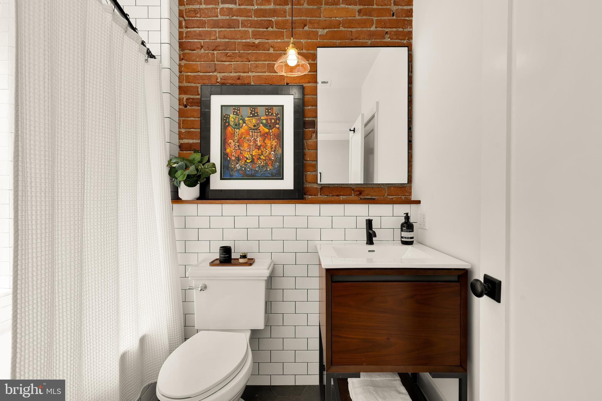 409 Columbia Road Northwest Washington, DC 20001 - Photo 33 of 41 a bathroom with a sink a toilet and mirror