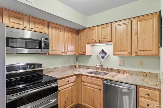 a kitchen with stainless steel appliances granite countertop a stove microwave and sink