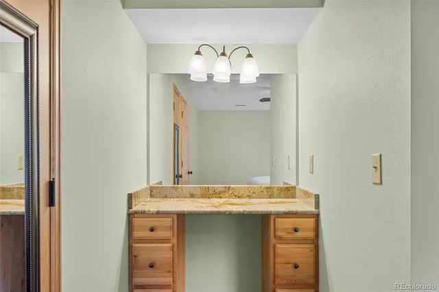 a bathroom with a granite countertop sink and a mirror