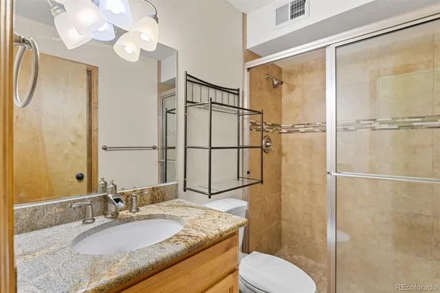 a bathroom with a granite countertop sink toilet and shower