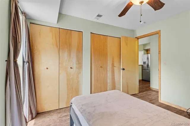 a view of a bedroom with a chandelier fan and a bathroom