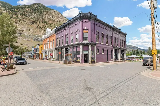 a city street lined with parked cars and buildings
