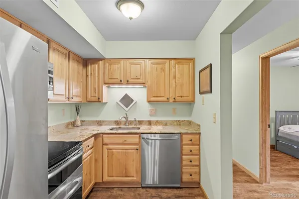 a kitchen with stainless steel appliances granite countertop a sink stove and refrigerator