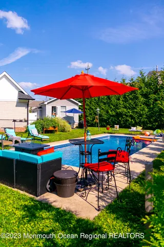 an outdoor sitting area with red umbrella