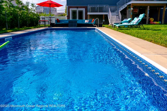 a view of an house with swimming pool and yard
