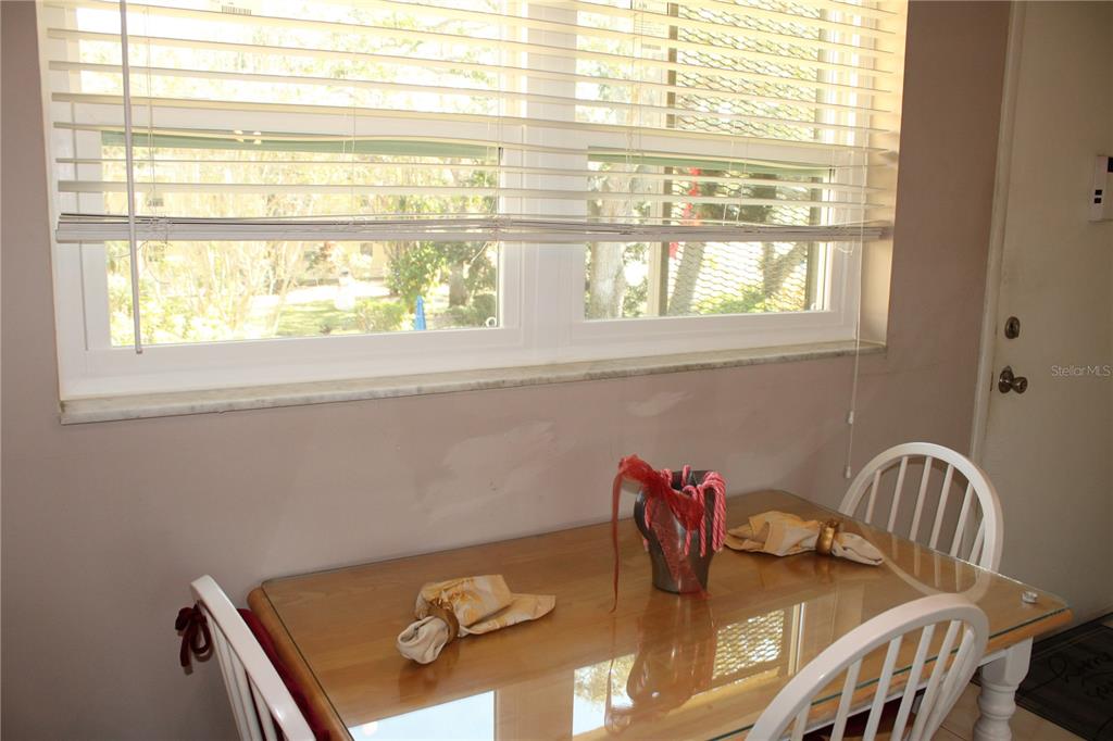 11485 Oakhurst Road, Unit 1200215 Largo, FL 33774 - Photo 13 of 68 a view of a dining room with furniture and a window