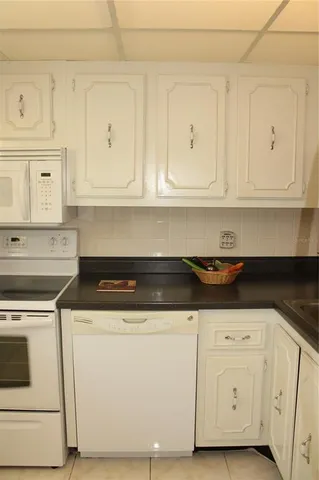 a living room with furniture kitchen view and a chandelier