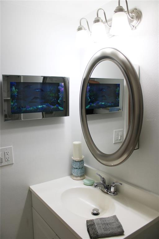 11485 Oakhurst Road, Unit 1200215 Largo, FL 33774 - Photo 23 of 68 a bathroom with a sink a mirror and a toilet