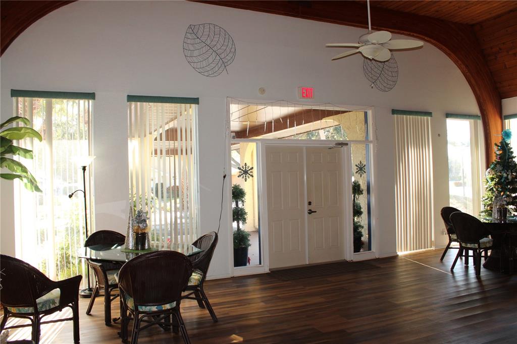 11485 Oakhurst Road, Unit 1200215 Largo, FL 33774 - Photo 45 of 68 a view of a dining room with furniture window and wooden floor