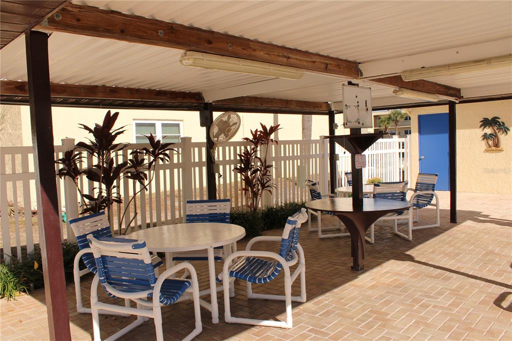 11485 Oakhurst Road, Unit 1200215 Largo, FL 33774 - Photo 55 of 68 a patio with yard table and chairs