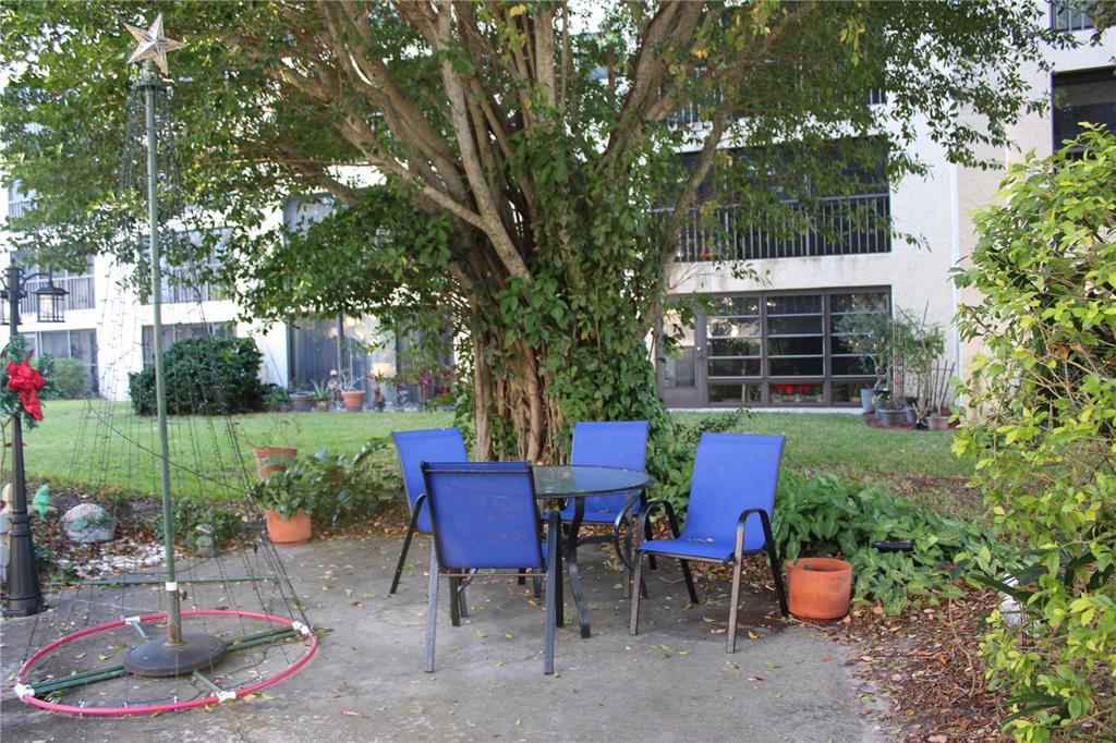 11485 Oakhurst Road, Unit 1200215 Largo, FL 33774 - Photo 61 of 68 a view of a chairs and table in backyard of the house