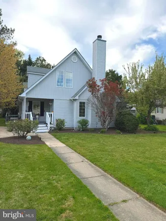 a front view of a house with a garden and yard