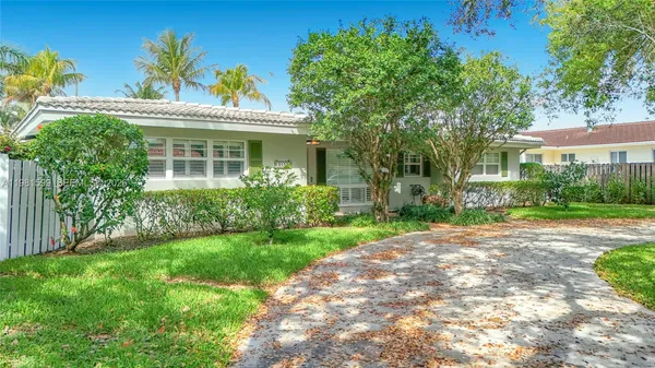 a view of a yard in front of a house with a large tree