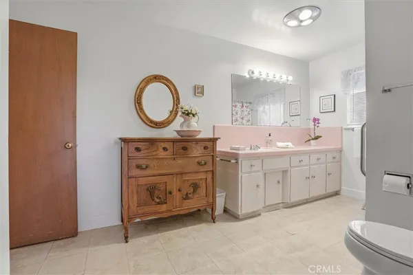 a bathroom with a granite countertop sink mirror vanity and toilet