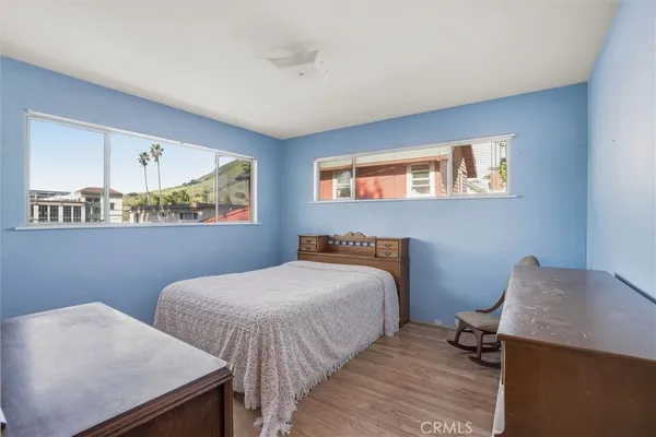 a bedroom with a bed and two windows