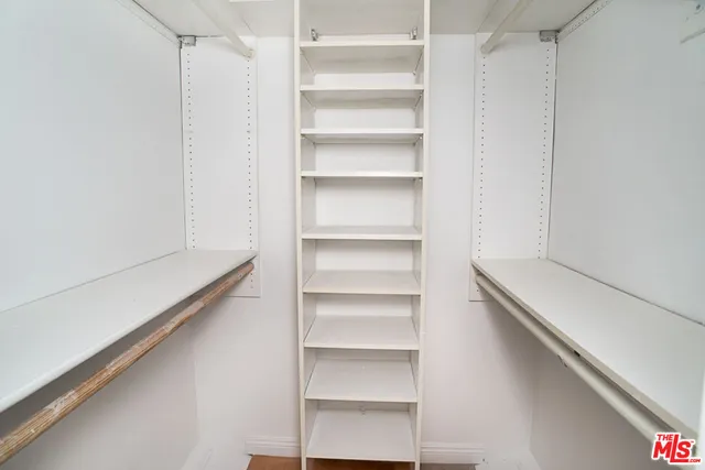 a room with walk in closet and empty racks
