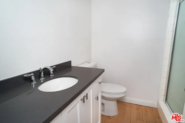 a bathroom with a granite countertop toilet sink and mirror