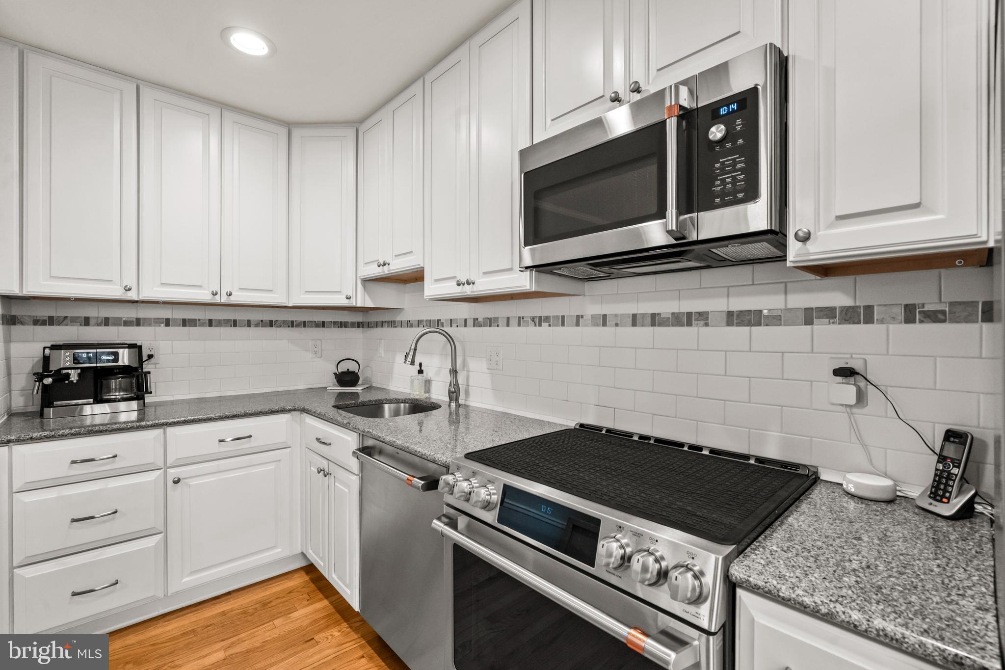 4228 40th Street Northwest Washington, DC 20016 - Photo 14 of 57 a kitchen with stainless steel appliances granite countertop a sink stove and microwave