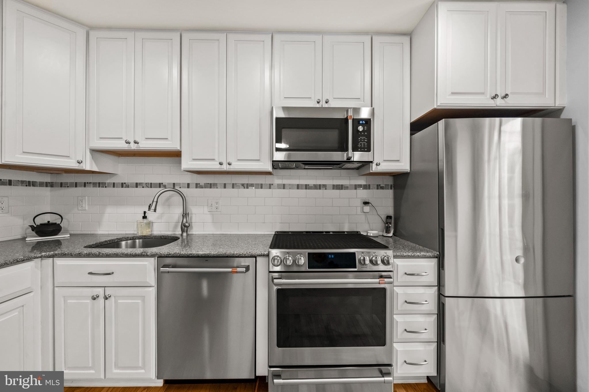 4228 40th Street Northwest Washington, DC 20016 - Photo 16 of 57 a kitchen with granite countertop white cabinets and stainless steel appliances