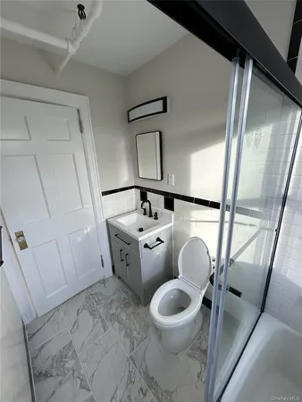 a bathroom with a toilet sink and mirror