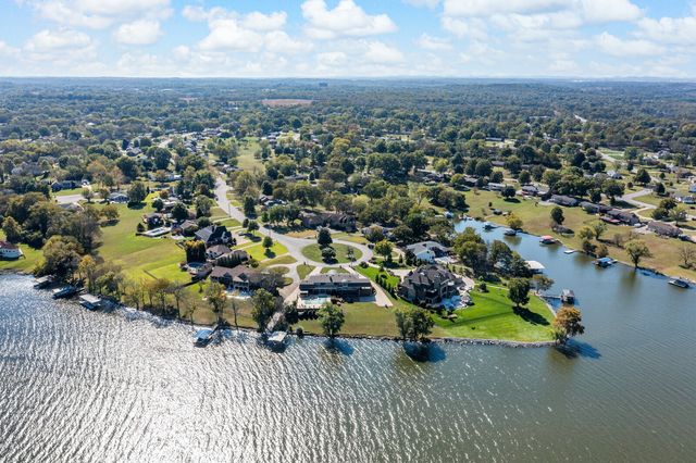 a dining room with wooden floor a chandelier a wooden table and chairs