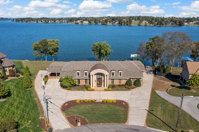 an aerial view of a house with a garden and lake view