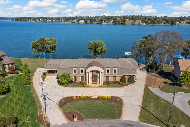an aerial view of a house with a garden and lake view