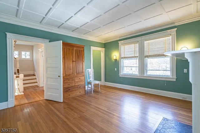 an empty room with wooden floor closet and windows