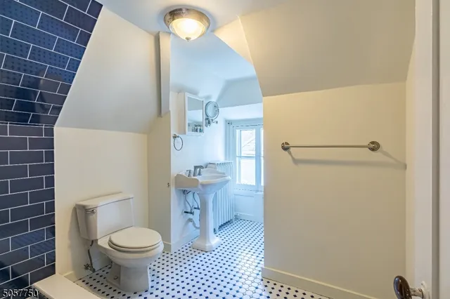 a bathroom with a granite countertop toilet and a sink