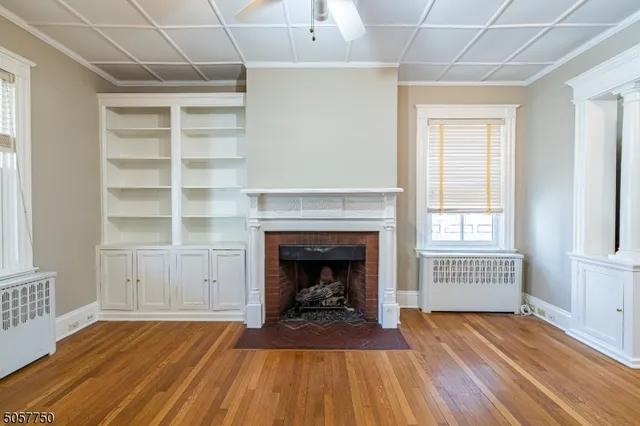 a living room with wooden floors and fireplace