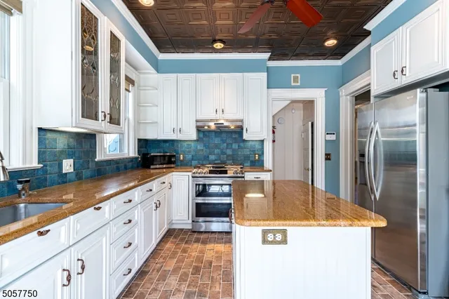 a kitchen with stainless steel appliances granite countertop a stove a refrigerator a sink and dishwasher