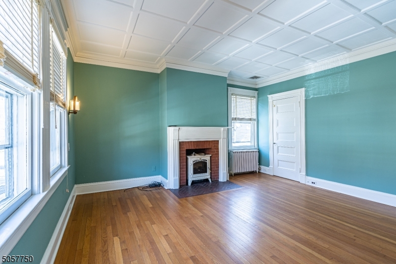 12 Wetmore Avenue, Unit 1 Morristown, NJ 07960 - Photo 10 of 26 an empty room with wooden floor fireplace and windows