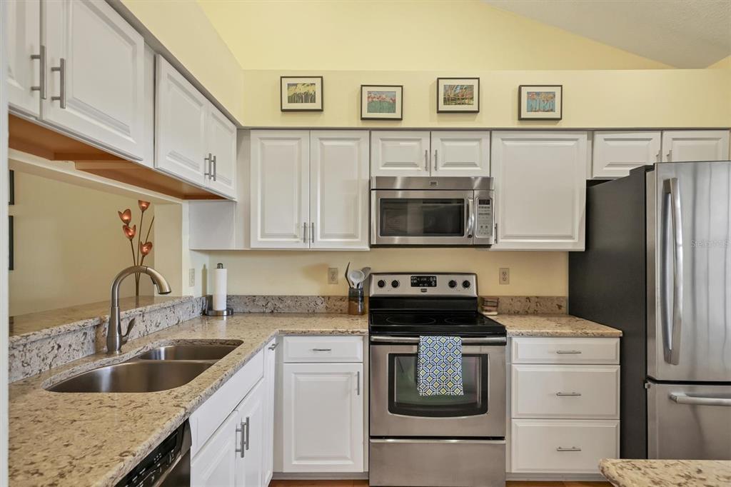 4513 Morningside, Unit 4 Sarasota, FL 34235 - Photo 17 of 81 a kitchen with granite countertop a sink stove and refrigerator