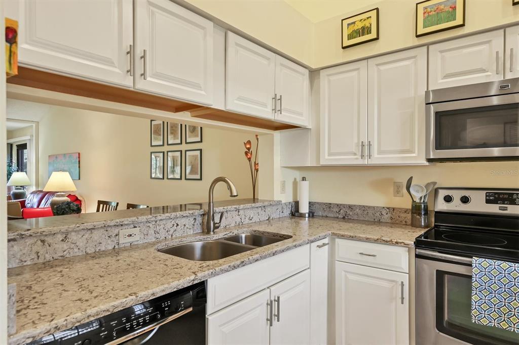 4513 Morningside, Unit 4 Sarasota, FL 34235 - Photo 18 of 81 a kitchen with stainless steel appliances granite countertop a sink stove and cabinets