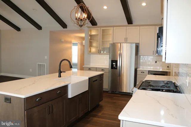 a kitchen with a sink stainless steel appliances a counter space and cabinets