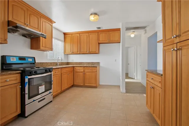 a kitchen with stainless steel appliances granite countertop a stove a sink and a refrigerator
