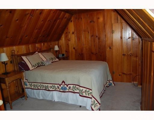 29053 Cedar Terrace Lake Arrowhead, CA 92321 - Photo 4 of 8 a bed sitting in a bedroom next to a wooden cabinet