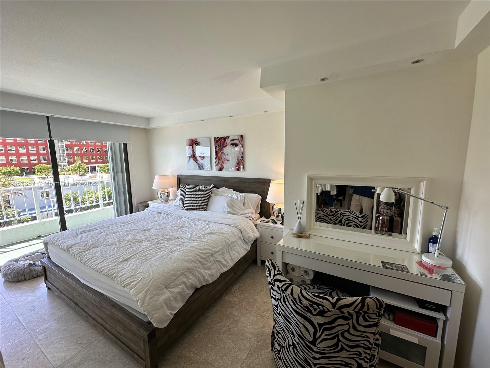 200 Southeast 15th Road, Unit 5J Miami, FL 33129 - Photo 13 of 20 a bedroom with a bed and a flat tv screen on the dresser