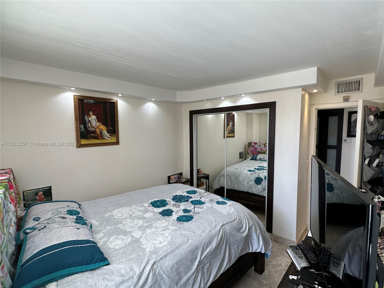 200 Southeast 15th Road, Unit 5J Miami, FL 33129 - Photo 18 of 20 a bedroom with a bed and a flat tv screen on the dresser