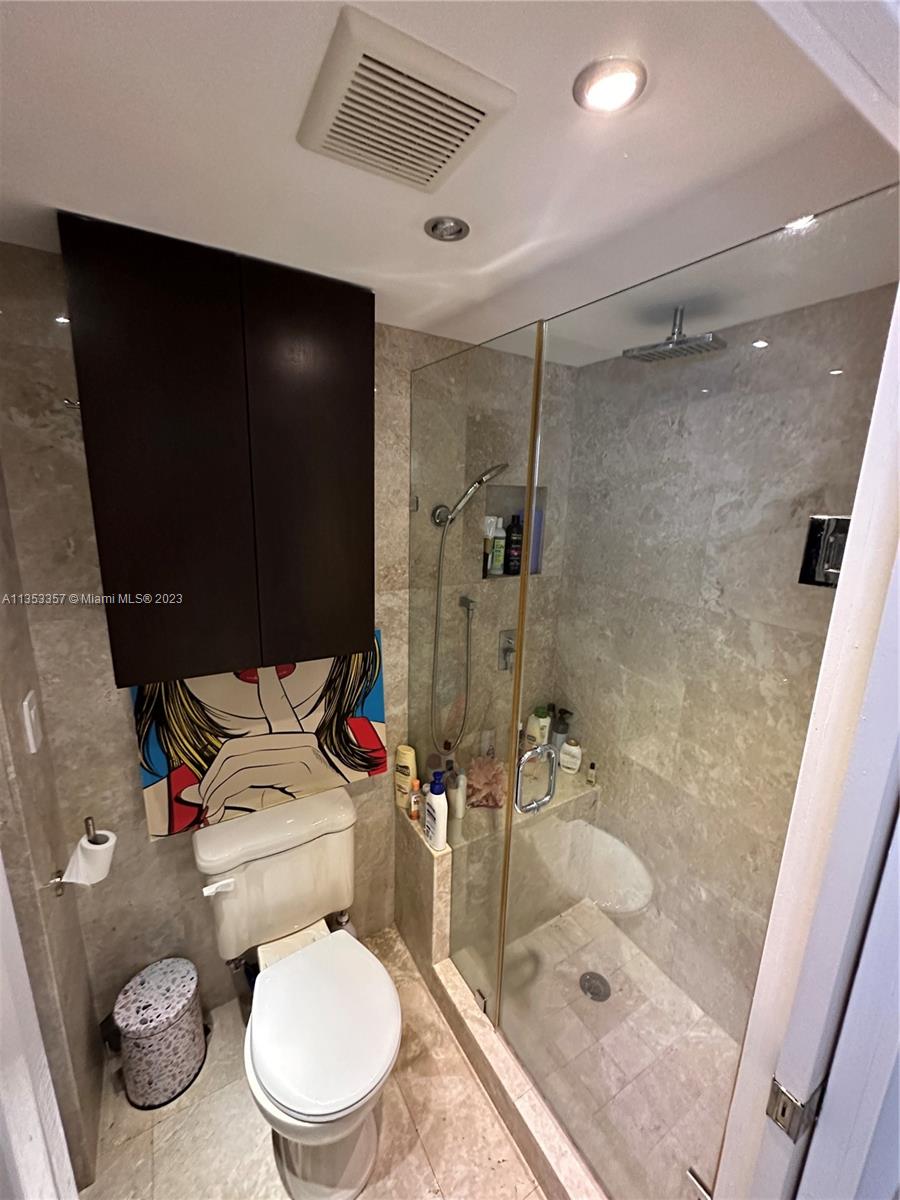 200 Southeast 15th Road, Unit 5J Miami, FL 33129 - Photo 19 of 20 a white toilet sitting next to a bathroom sink and a shower