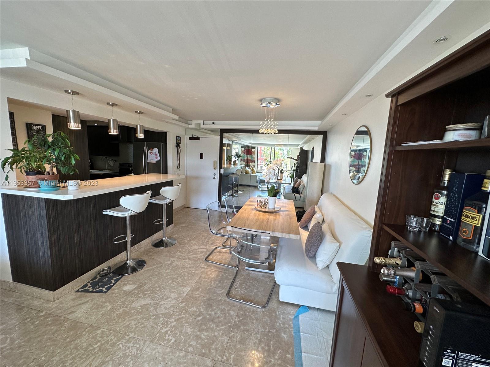 200 Southeast 15th Road, Unit 5J Miami, FL 33129 - Photo 8 of 20 a living room with furniture a flat screen tv and kitchen view